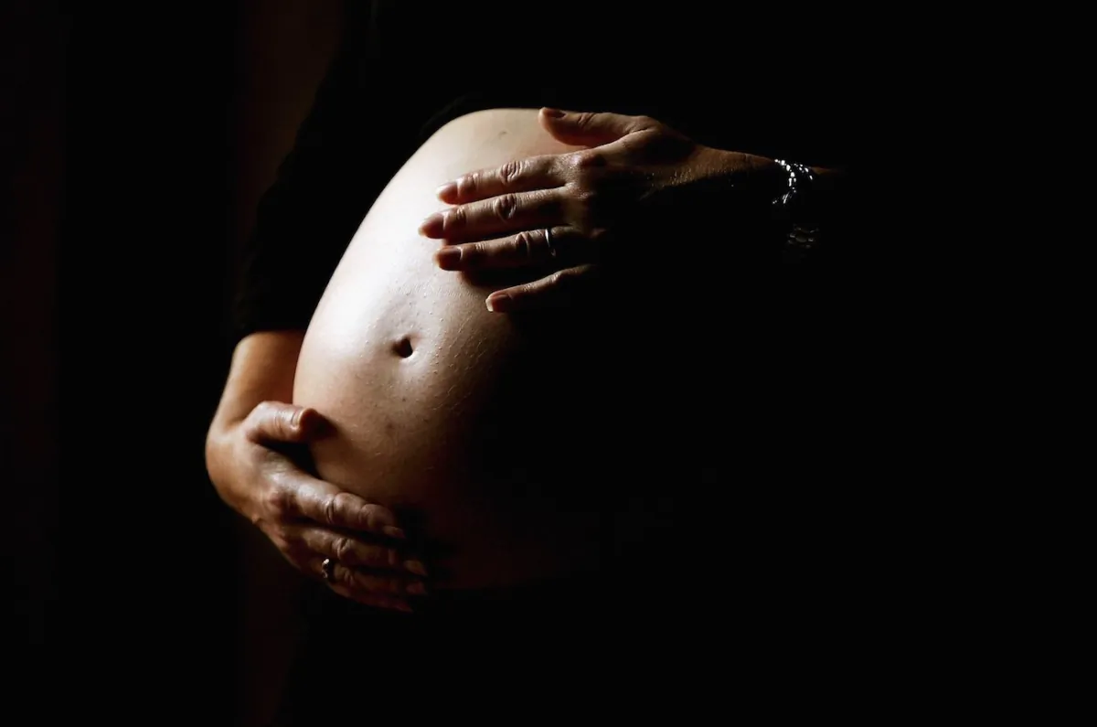 A pregnant woman holds her stomach in a file image. (Ian Waldie/Getty Images)