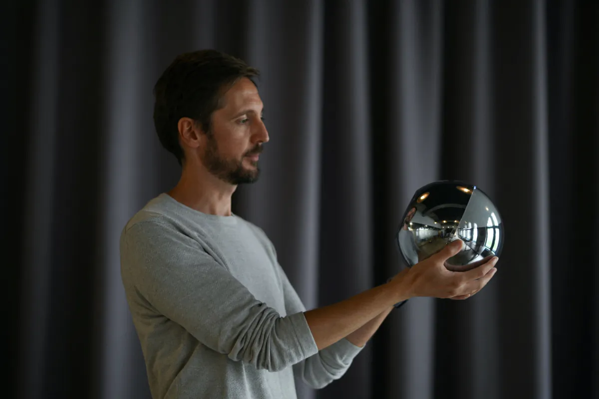 Ricardo Macieira, regional manager, Europe holds the biometric imaging device, the Orb of the identity and financial public utility Worldcoin, in Berlin, on Aug. 1, 2023. (Annegret Hilse/Reuters)