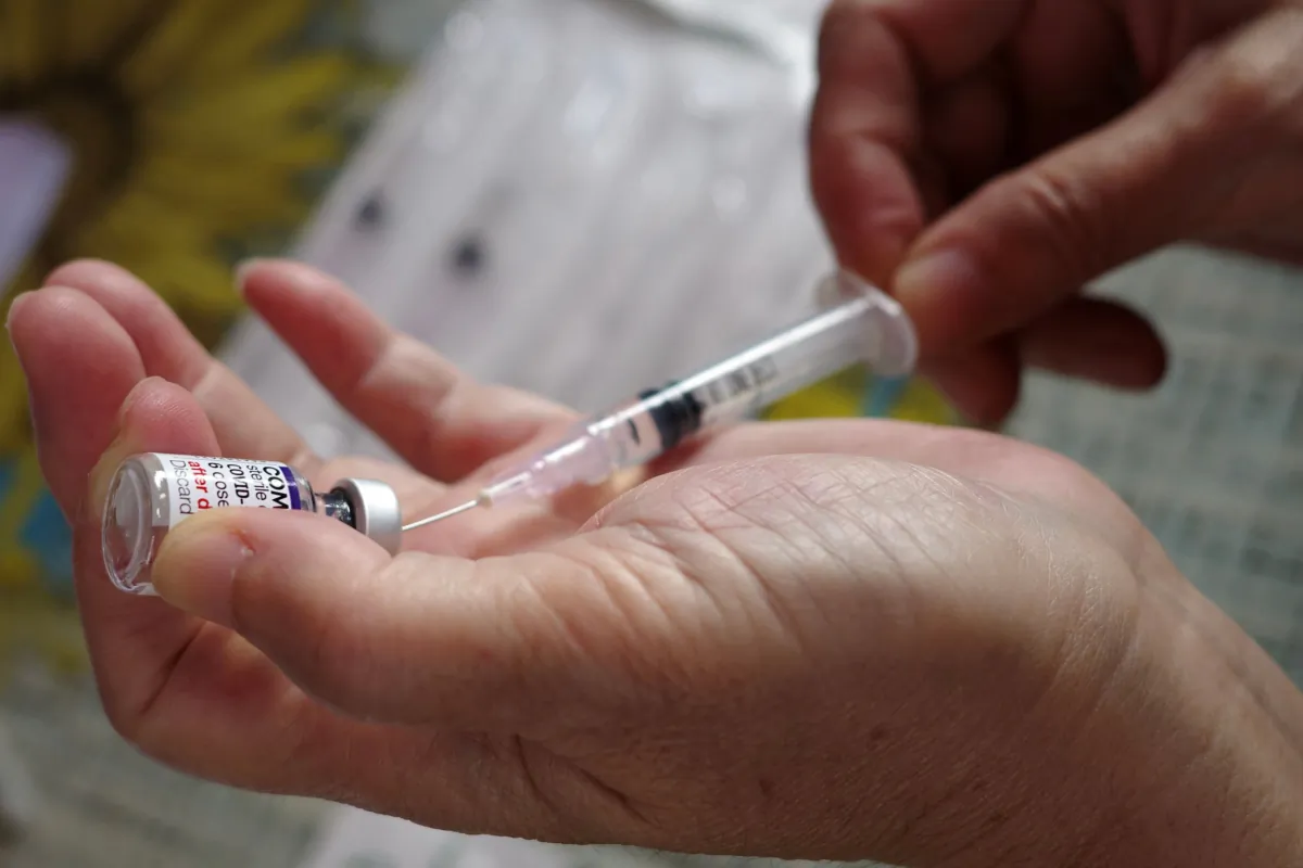 A health care worker prepares a COVID-19 vaccine in a file photo. (Bay Ismoyo/AFP via Getty Images)