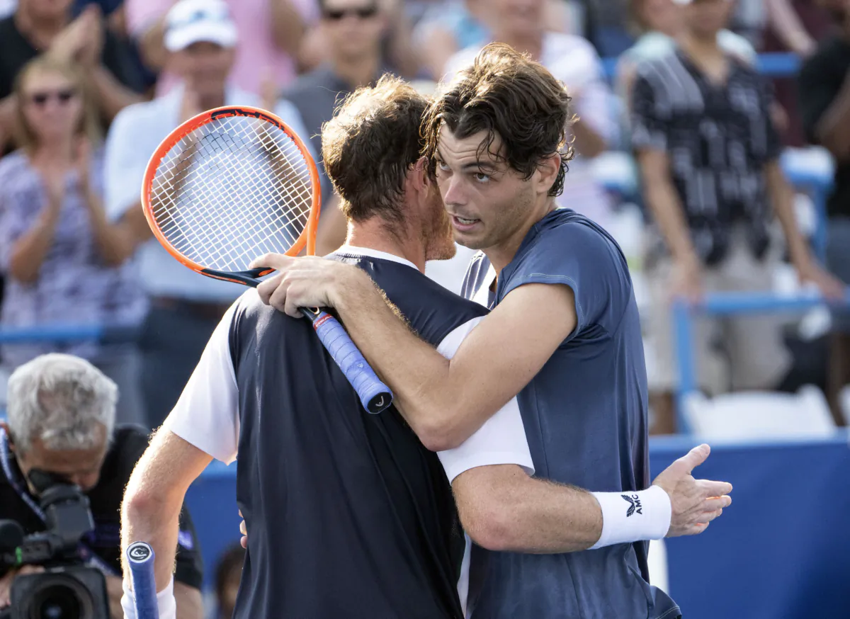 Taylor Fritz, right, embraces Andy Murray after their match during the DC Open tennis tournament in Washington, Aug. 4, 2023. (Minh Connors/The Washington Post via AP)