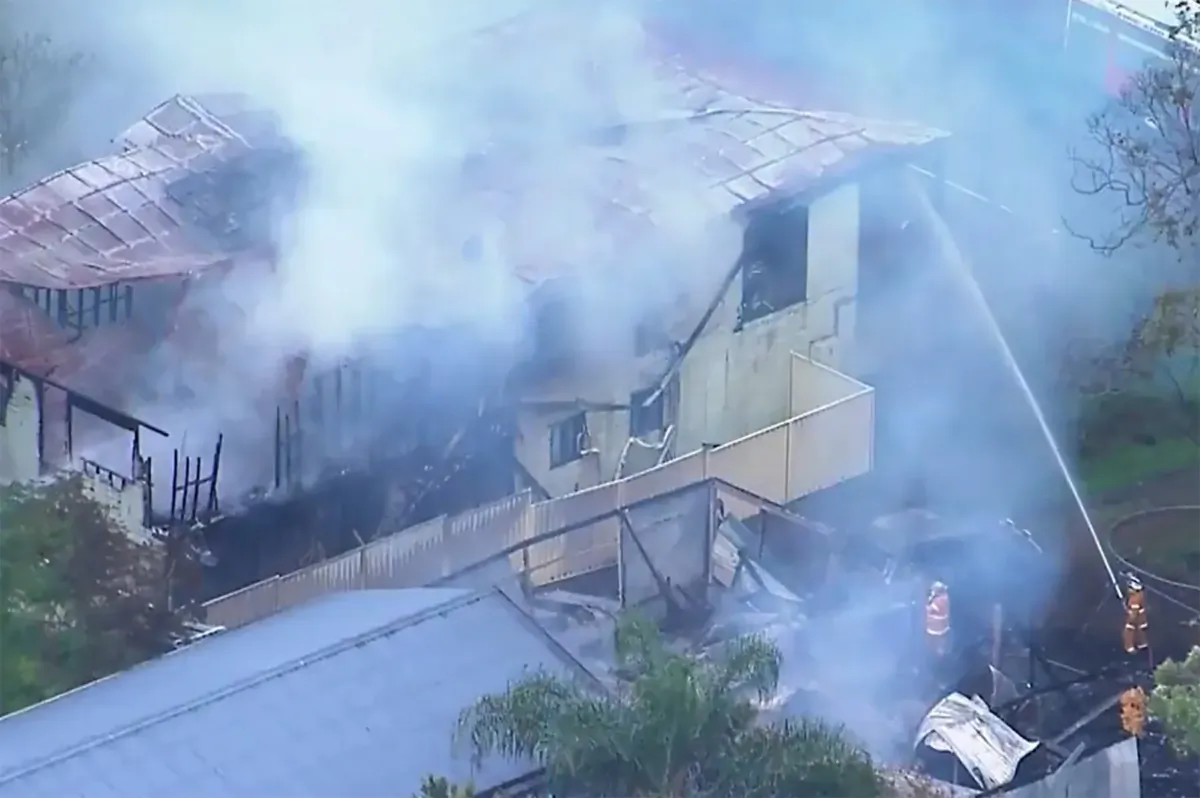 A supplied screen-grab obtained Sunday, Aug. 6, 2023, of Queensland Fire and Emergency crew at the scene of a house fire in Russell Island, Queensland. Six members of the one family, including five children, are feared dead after a fire broke out in a home on an island off the coast of Brisbane. (AAP Image/Nine News)