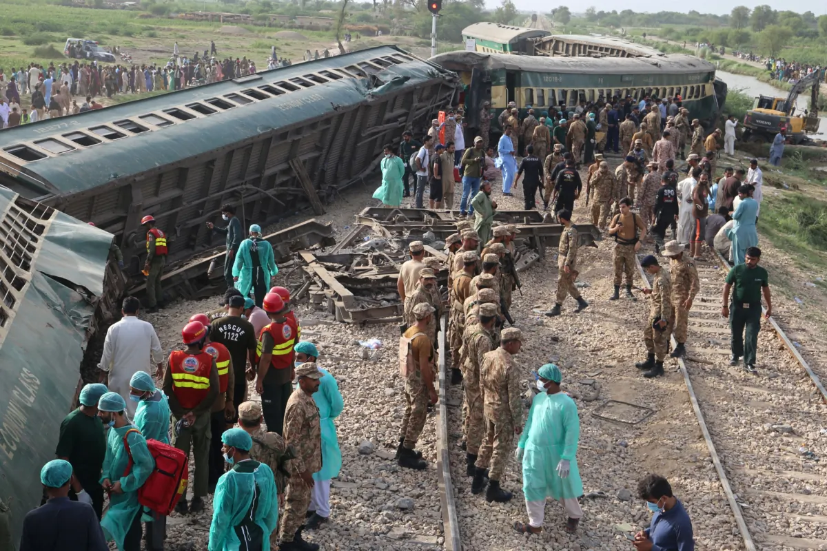 Paramilitary rangers and volunteers inspect the carriages at the accident site following the derailment of a passenger train in Nawabshah, Pakistan, on Aug. 6, 2023. (Husnain Ali/AFP via Getty Images)