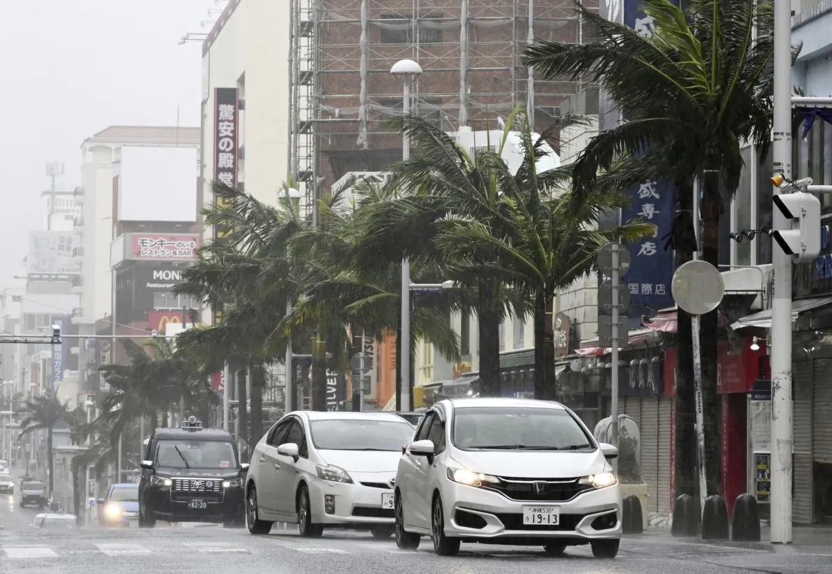 Vehicles drive through a street in a strong wind in Naha, Okinawa prefecture, southern Japan, on Aug. 6, 2023. (Kyodo News via AP)
