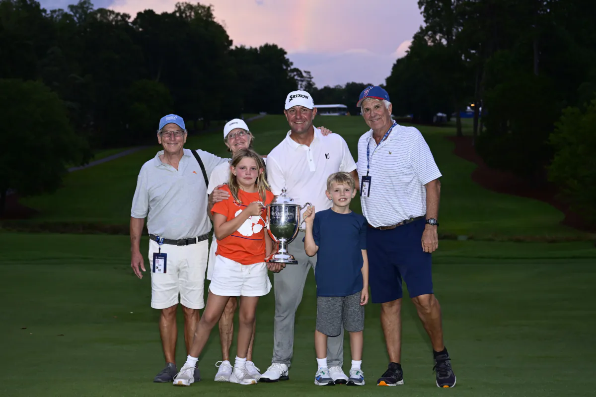 Lucas Glover of the United States poses with his family after winning the Wyndham Championship at Sedgefield Country Club in Greensboro, N.C., on August 6, 2023. (Logan Whitton/Getty Images)