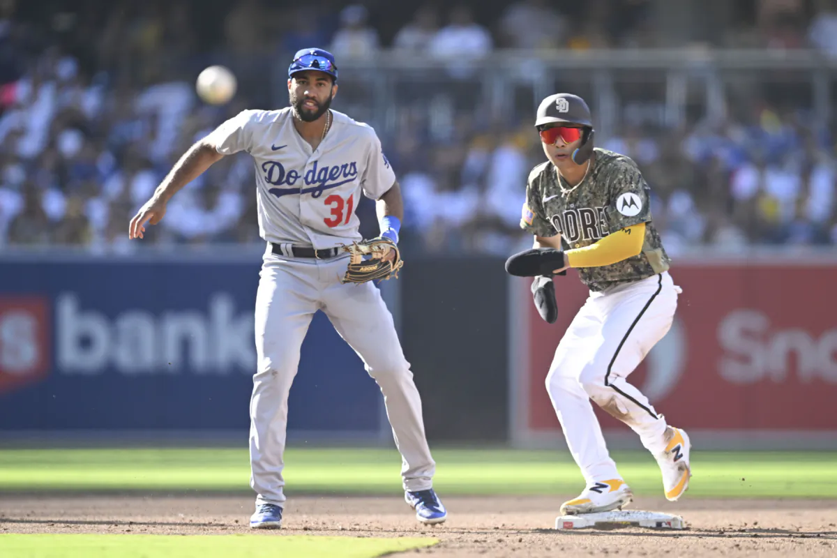 Amed Rosario (31) of the Los Angeles Dodgers turns a double play over Ha-Seong Kim (7) of the San Diego Padres in the third inning at Petco Park in San Diego on August 6, 2023. (Denis Poroy/Getty Images)