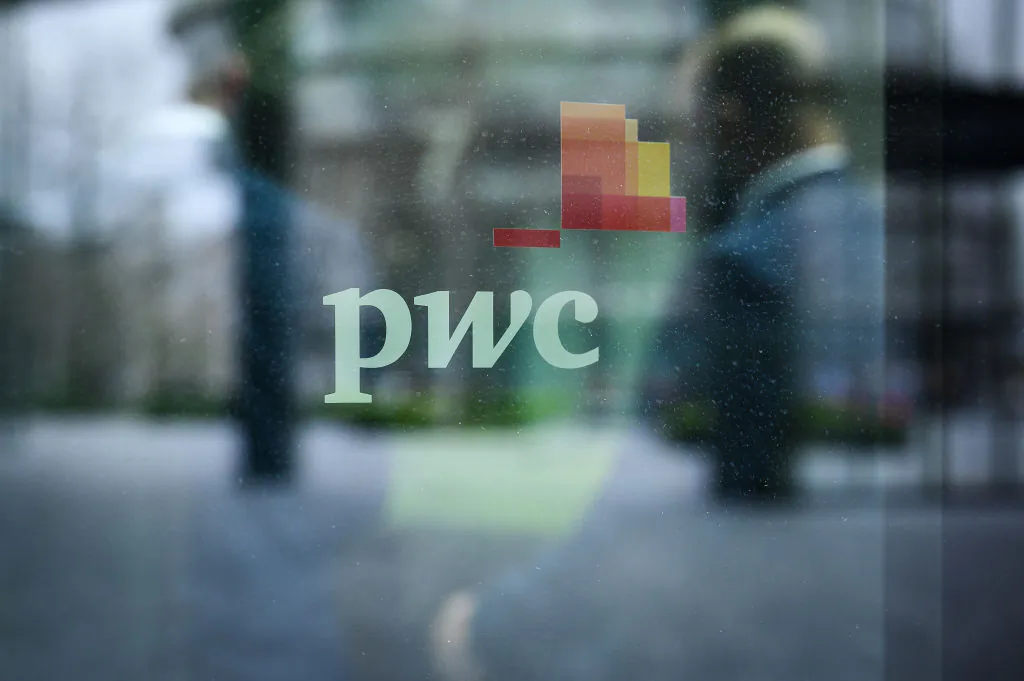 People walk past a sign on a window on the exterior of the PWC London offices in London, on March 31, 2021. (Leon Neal/Getty Images)