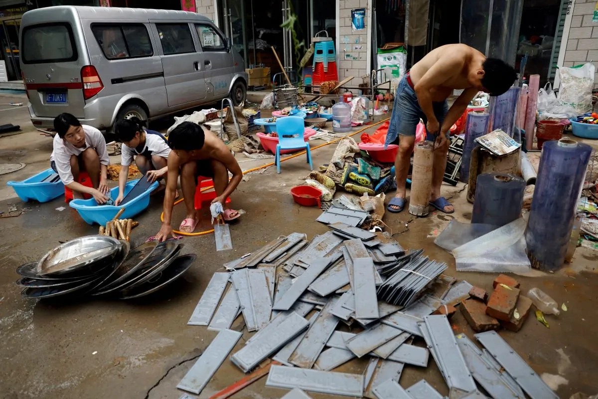 People clean muddied items outside a store after the rains and floods brought by remnants of Typhoon Doksuri, in Zhuozhou, Hebei Province, China, on Aug. 7, 2023. (Tingshu Wang/Reuters)