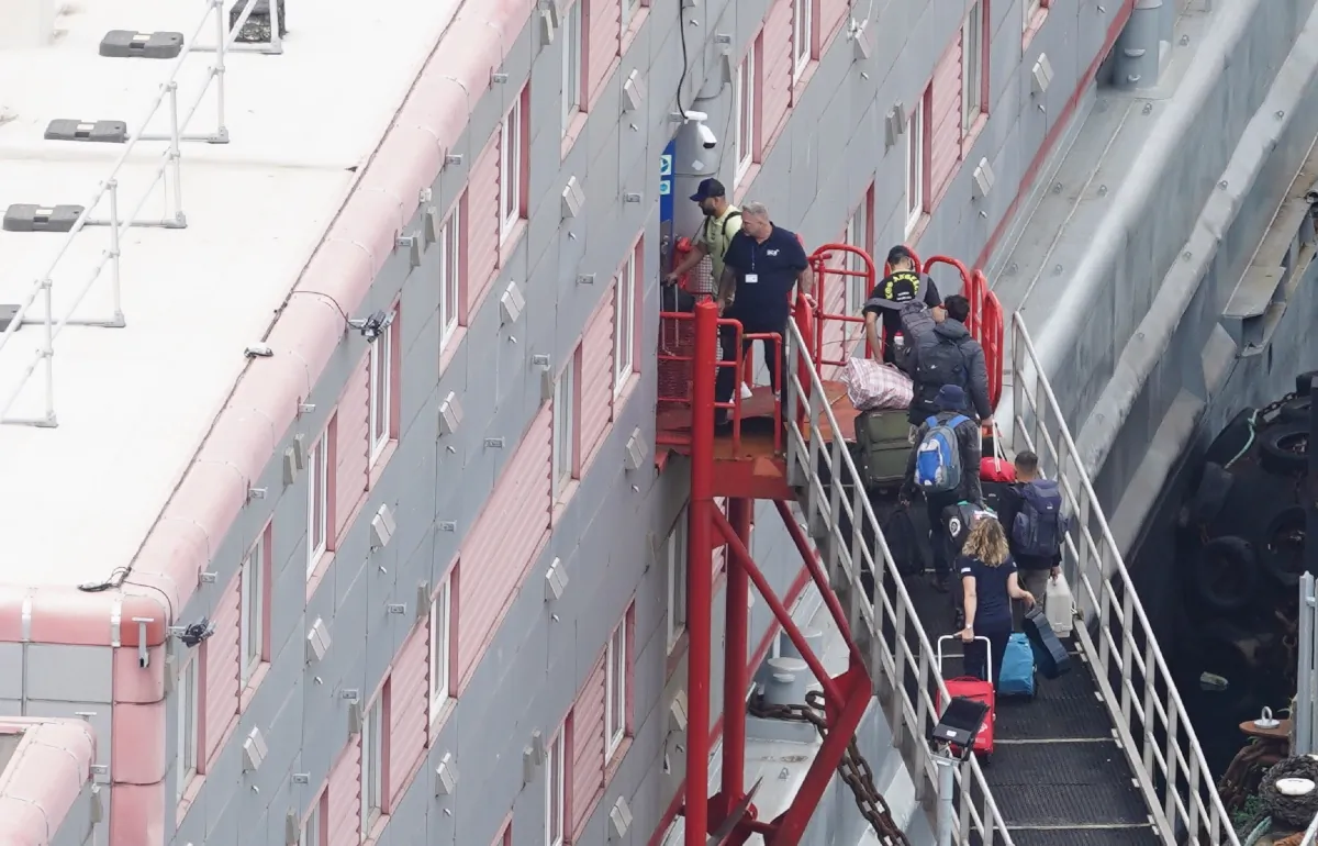 People boarding the Bibby Stockholm accommodation barge at Portland Port in Dorset, England, on Aug. 7, 2023. (PA)