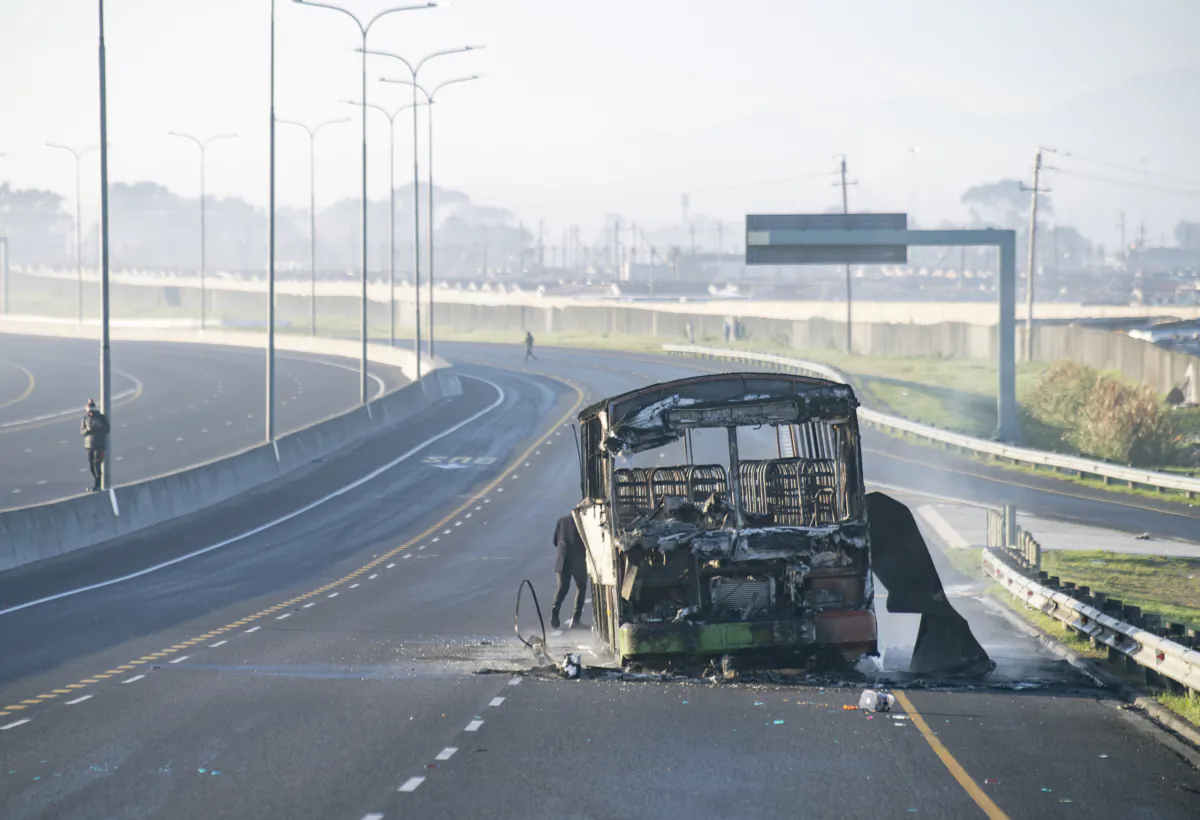 A burnt out bus stands on a freeway on the outskirts of Cape Town, South Africa, on Aug. 7, 2023. (AP Photo)