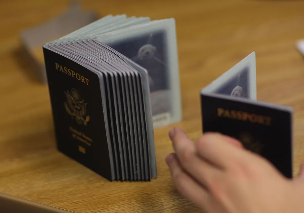 A Passport Processing employee uses a stack of blank passports to print a new one at the Miami Passport Agency in Miami on June 22, 2007. (Joe Raedle/Getty Images)