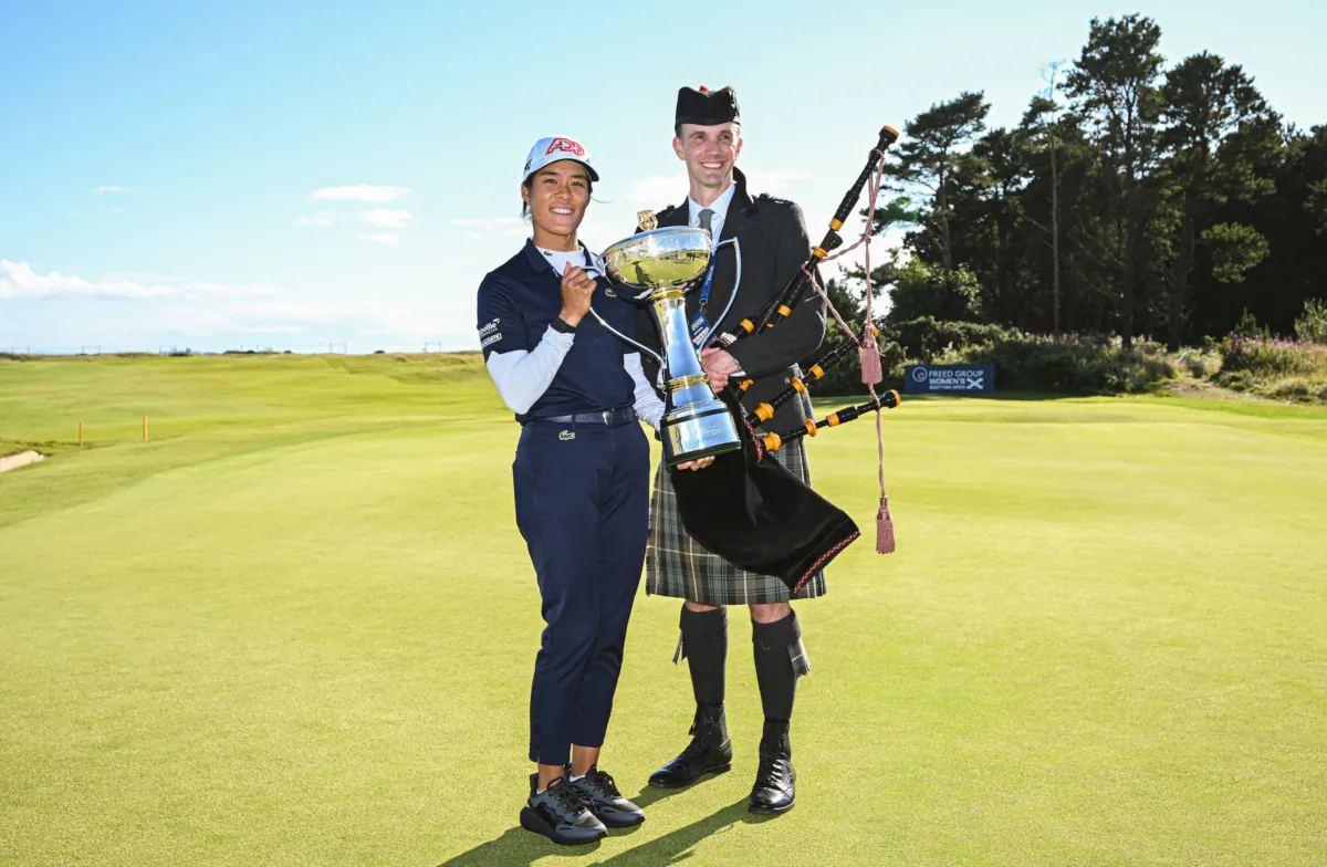 Celine Boutier of France poses with the championship trophy side with a traditional Scottish bagpiper after winning the FREED GROUP Women's Scottish Open presented by Trust Golf at Dundonald Links Golf Course in Troon, Scotland, on August 6, 2023. (Octavio Passos/Getty Images)