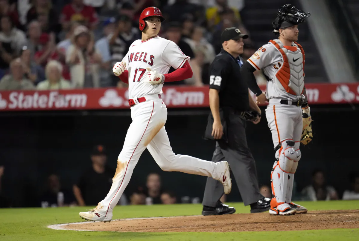 Shohei Ohtani (17) of the Los Angeles Angels scores a run as catcher Patrick Bailey (14) of the San Francisco Giants looks on in the sixth inning at Angel Stadium of Anaheim in Anaheim, Calif., on Aug. 7, 2023. (Kevork Djansezian/Getty Images)