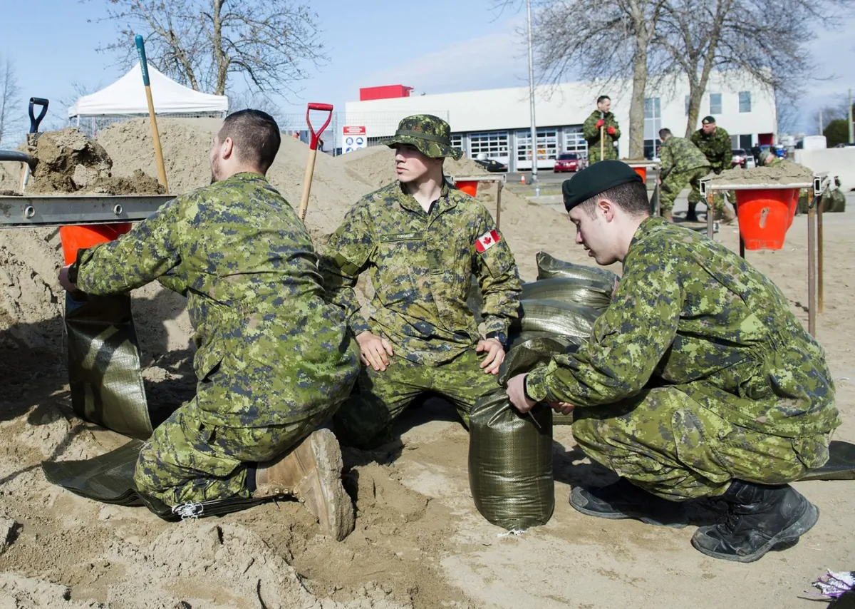 Members of the Canadian Armed Forces fill sandbags following spring flooding in the town of Rigaud, Que, west of Montreal on April 21, 2019. (The Canadian Press/Graham Hughes)