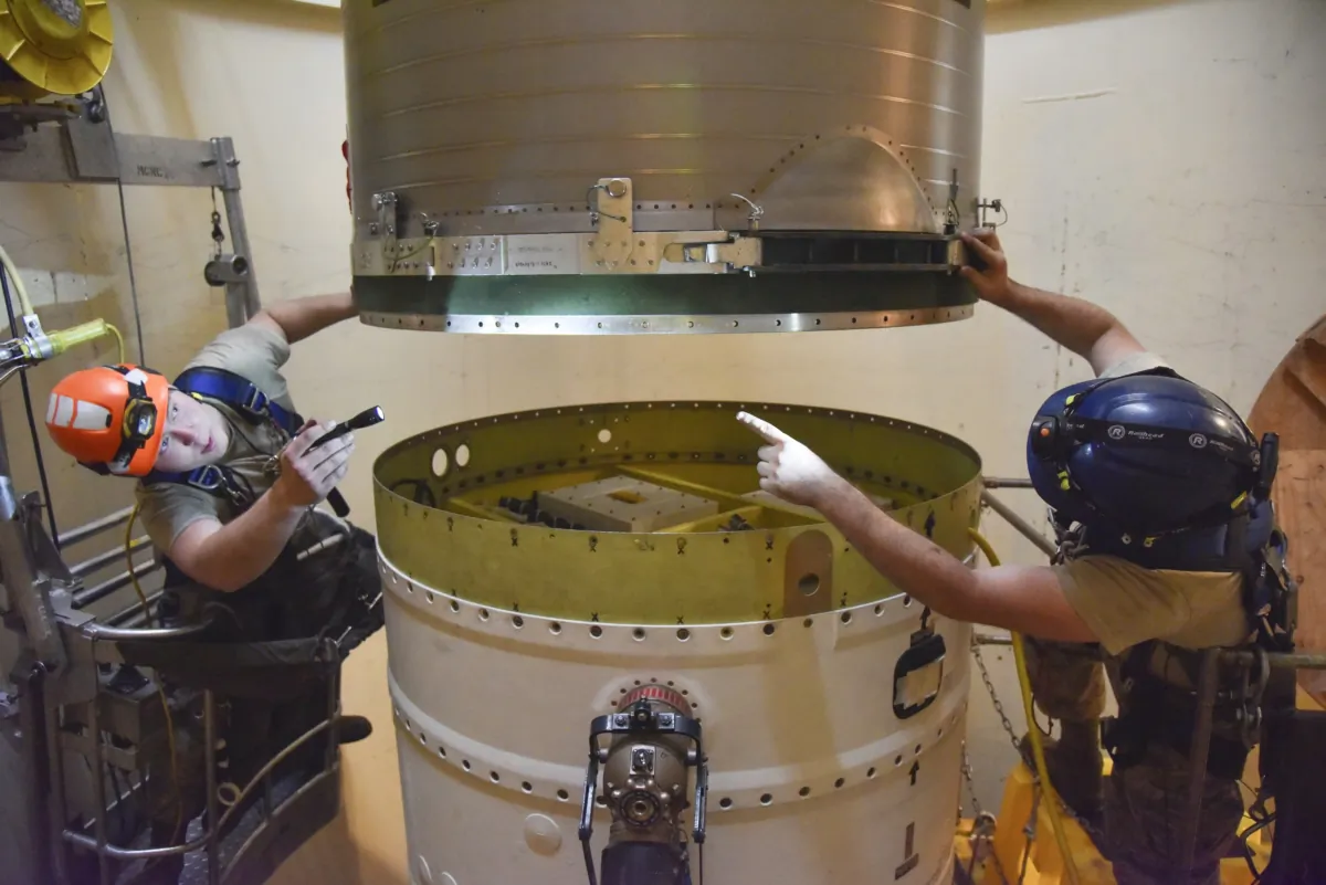 Airman 1st Class Jackson Ligon (L) and Senior Airman Jonathan Marinaccio, 341st Missile Maintenance Squadron technicians connect a re-entry system to a spacer on an intercontinental ballistic missile during a Simulated Electronic Launch-Minuteman test at a launch facility near Malmstrom Air Force Base in Great Falls, Mont., on Sept. 22, 2020. (Senior Airman Daniel Brosam/U.S. Air Force via AP)