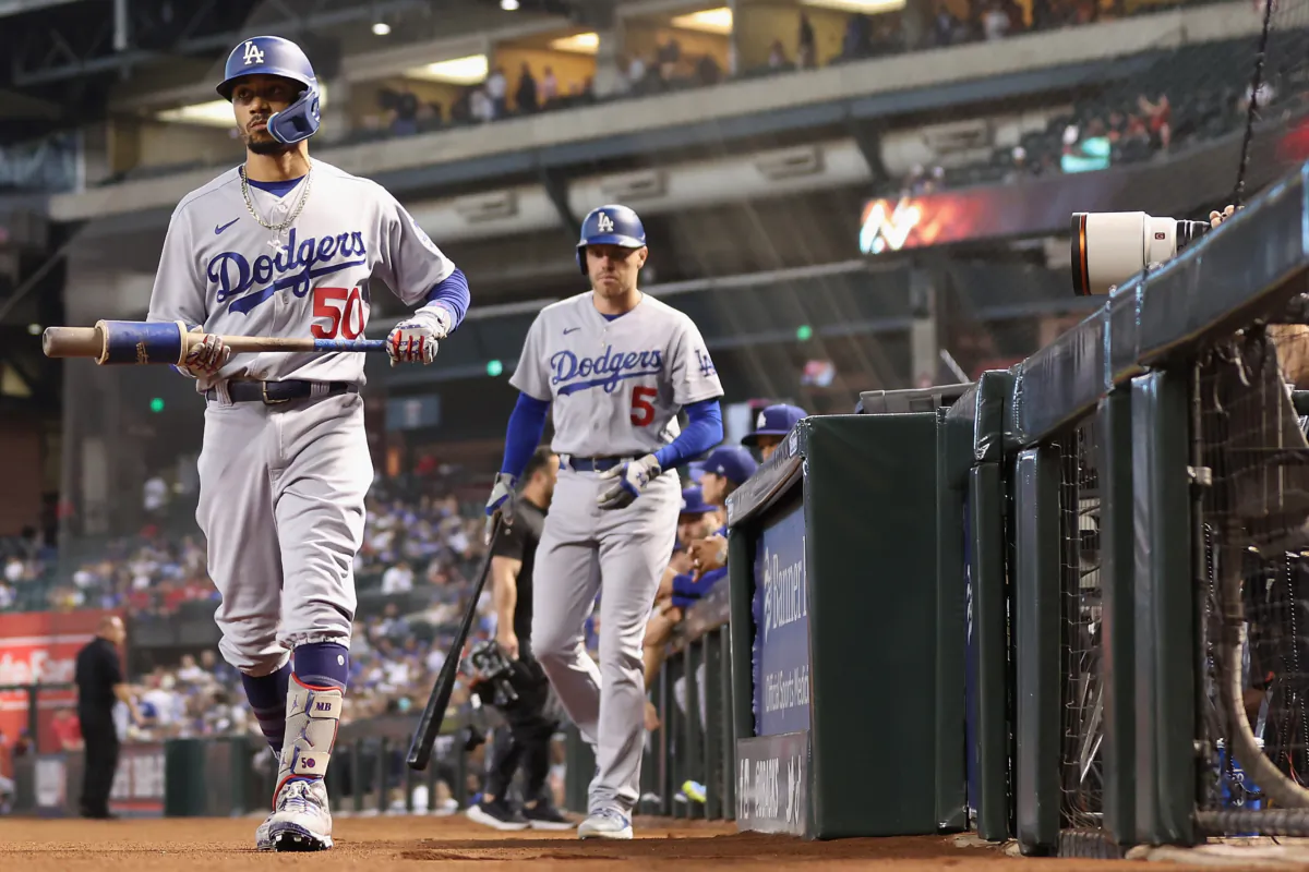 Mookie Betts (50) and Freddie Freeman (5) of the Los Angeles Dodgers walk out of the dugout to bat during the first inning of the MLB game against the Arizona Diamondbacks at Chase Field in Phoenix on Aug. 8, 2023. (Christian Petersen/Getty Images)