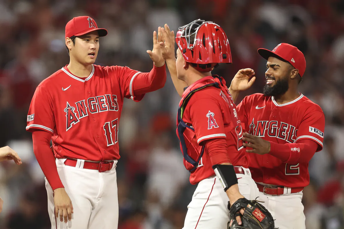 Shohei Ohtani (17) of the Los Angeles Angels celebrates with his teammates Matt Thaiss (21) and Luis Rengifo (2) after defeating the San Francisco Giants during the ninth inning of a game at Angel Stadium of Anaheim in Anaheim, Calif., on Aug. 8, 2023. (Michael Owens/Getty Images)