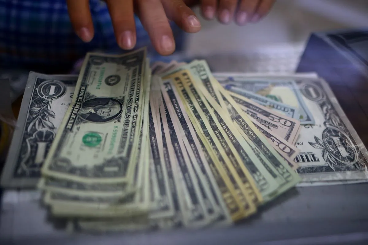 The employee of a currency exchange shop counts U.S. dollar banknotes in Ciudad Juarez, Mexico, on July 27, 2023. (Jose Luis Gonzalez/Reuters)