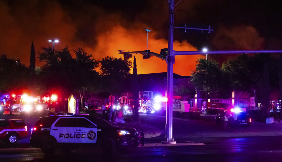 Fire crews and safety officials respond to a grass fire that forced evacuations in Cedar Park, Texas, on Aug. 8, 2023. (Sara Diggins/Austin American-Statesman via AP)