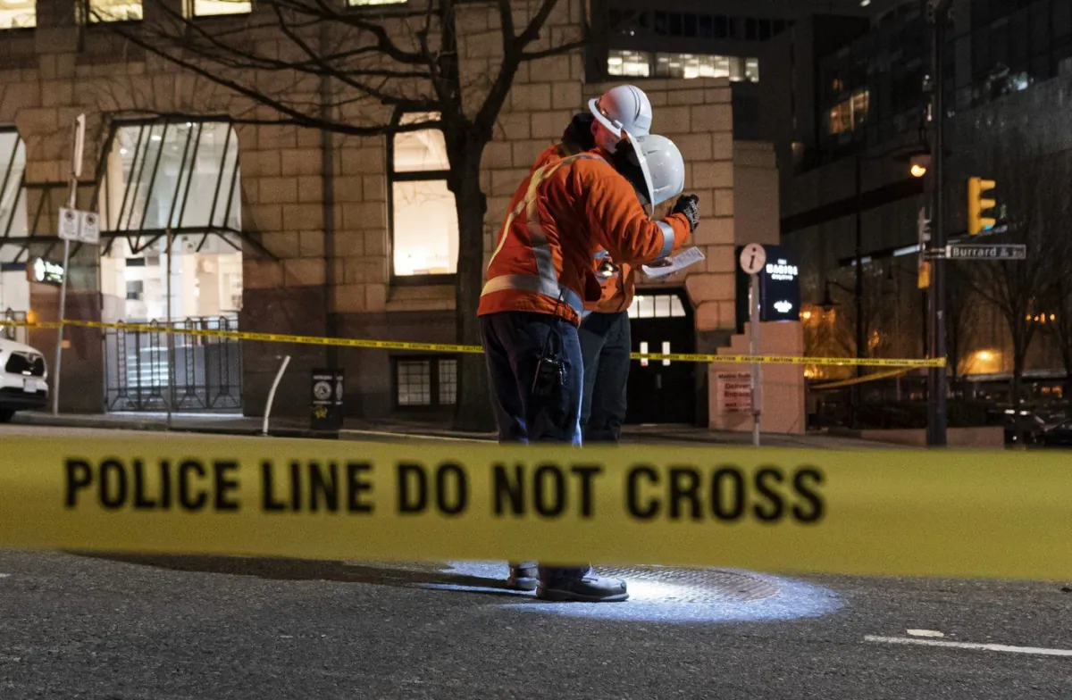 Officials investigate after a nearby underground electrical vault caught fire and and caused an explosion in downtown Vancouver, B.C., Feb. 24, 2023. (The Canadian Press/Rich Lam)