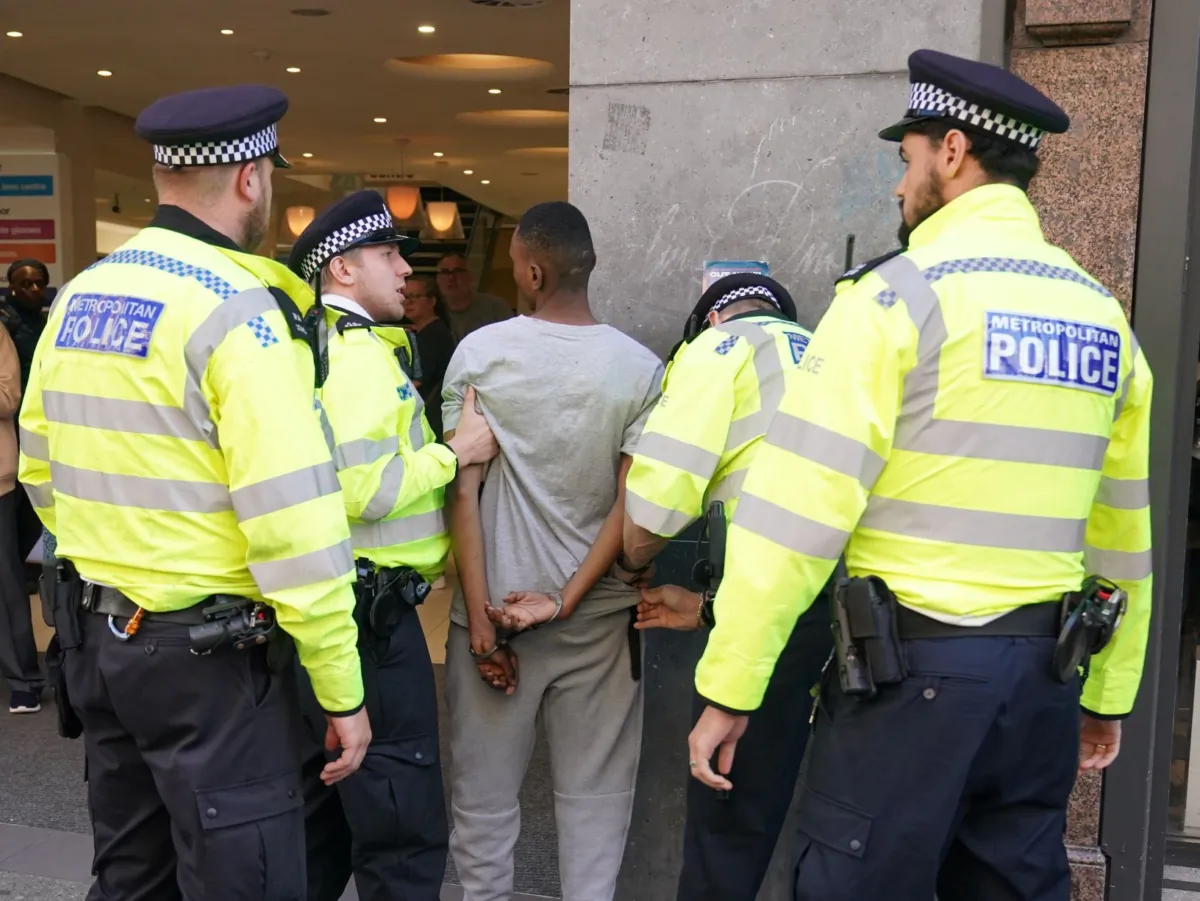 A man is detained outside McDonald's after a TikTok video encouraged disorder in Oxford Street, central London, on Aug. 9, 2023. (PA)