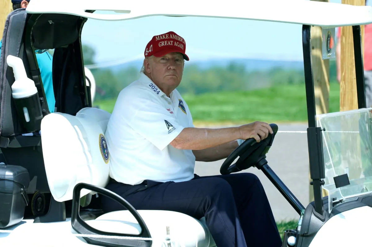 Former U.S. President and 2024 presidential hopeful Donald Trump drives a golf cart ahead of the LIV Golf Invitational series  tournament at Trump National Golf Club Bedminster in Bedminster, New Jersey, on Aug. 9, 2023. (Timothy A. Clary/AFP via Getty Images)