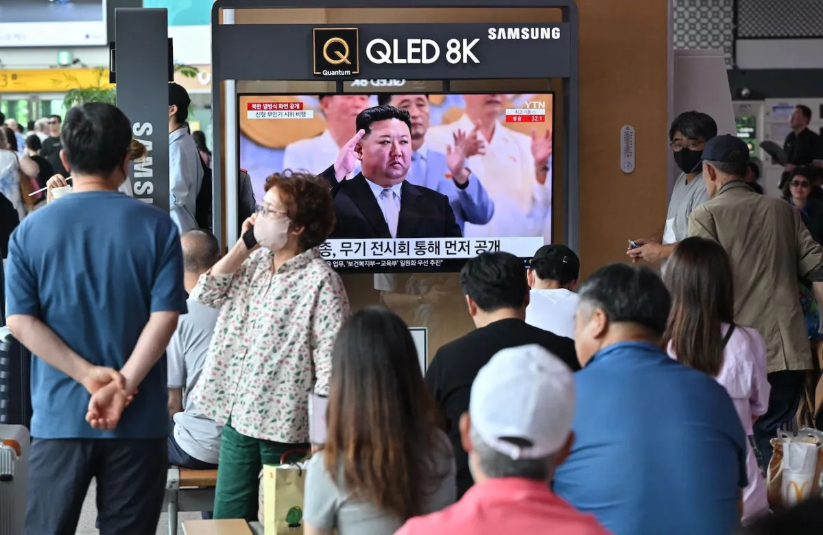 People watch a television screen showing a news broadcast with an image of North Korean leader Kim Jong Un attending a military parade held in Pyongyang to mark the 70th anniversary of the Korean War armistice, at a railway station in Seoul on July 28, 2023. (Jung Yeon-Je/AFP via Getty Images)
