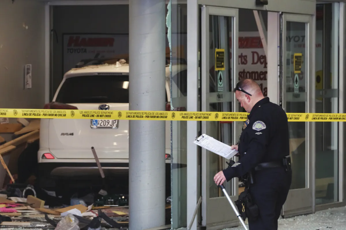 A police investigator surveys the scene of a vehicle crash at a Toyota Auto Dealership in the Mission Hills neighborhood of Los Angeles on Aug. 9, 2023. (Richard Vogel/AP Photo)
