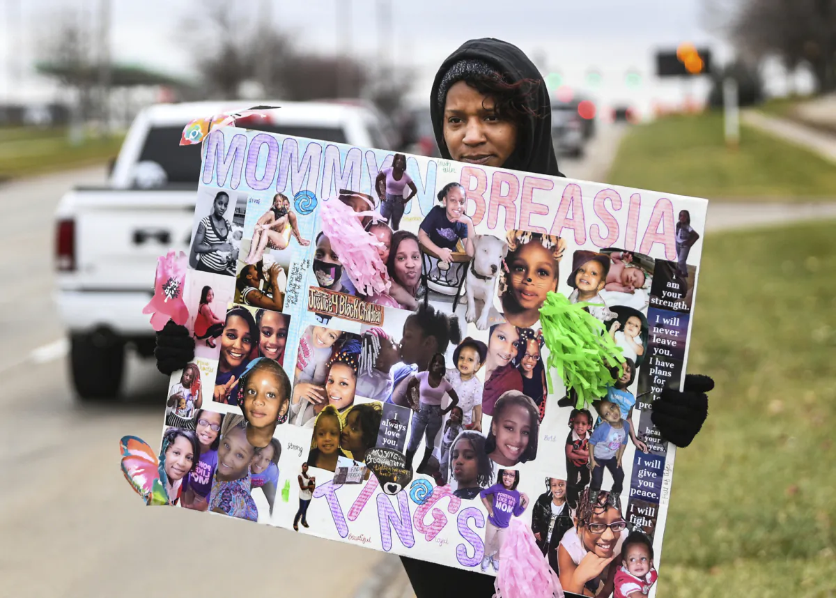 Aishia Lankford, mother of missing Breasia Terrell, 10, of Davenport, holds a sign during a march in her honor along 53rd Street in Davenport, Iowa on Nov. 14, 2020. (Meg McLaughlin/Quad City Times via AP)