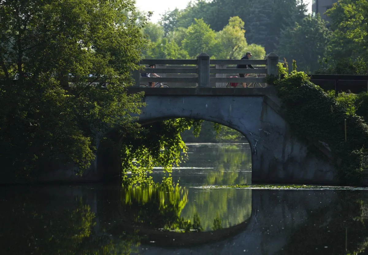 People make their way over Patterson Creek in Ottawa on Aug. 10, 2023. (The Canadian Press/Sean Kilpatrick)
