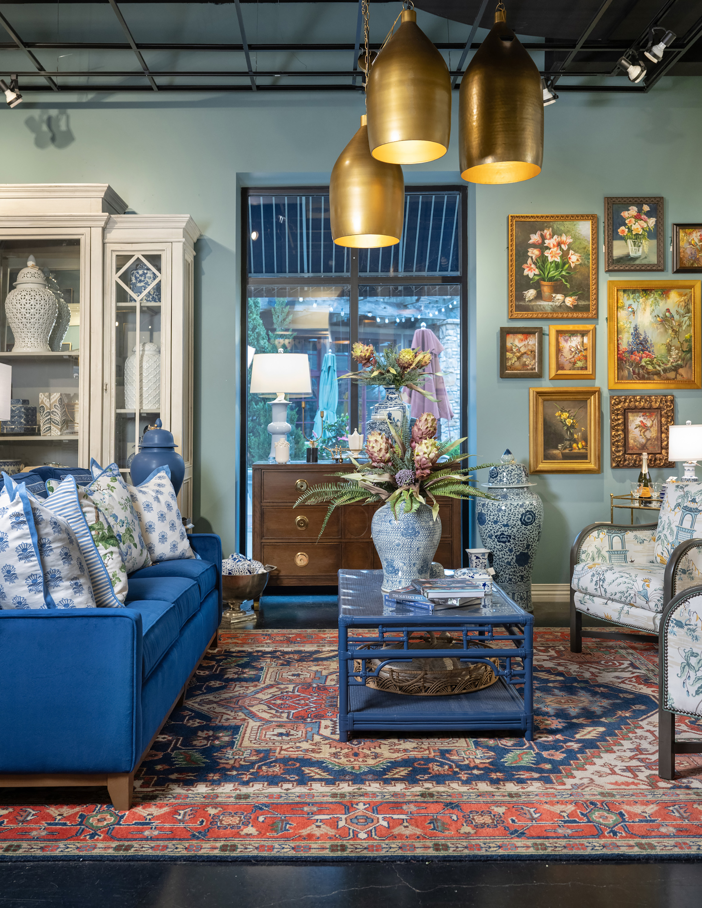 Statement lighting and a bold rug anchor the design in this new traditional living space.