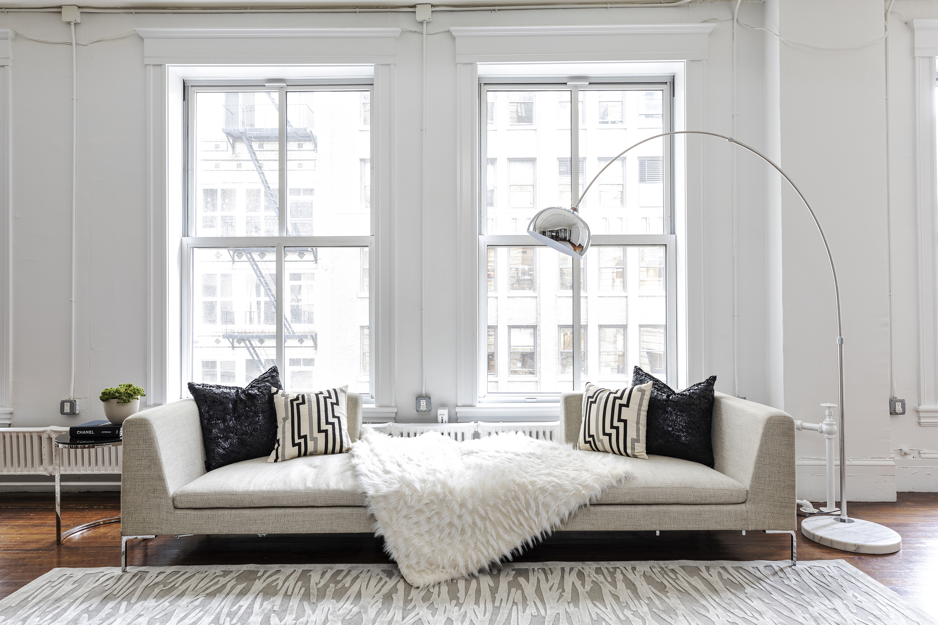 A light living room sofa is used to highlight a lofted space with high ceilings.