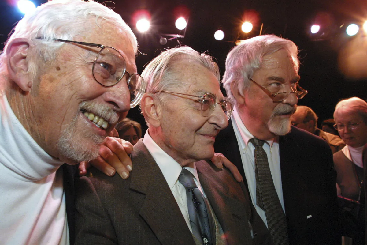 Lore Noto, the original producer of the off-Broadway musical "The Fantasticks," is flanked by the plays authors Tom Jones (L) and Harvey Schmidt at the tiny Sullivan Street Playhouse in New York's Greenwich Village on Jan. 13, 2002. (Tina Fineberg/AP Photo)