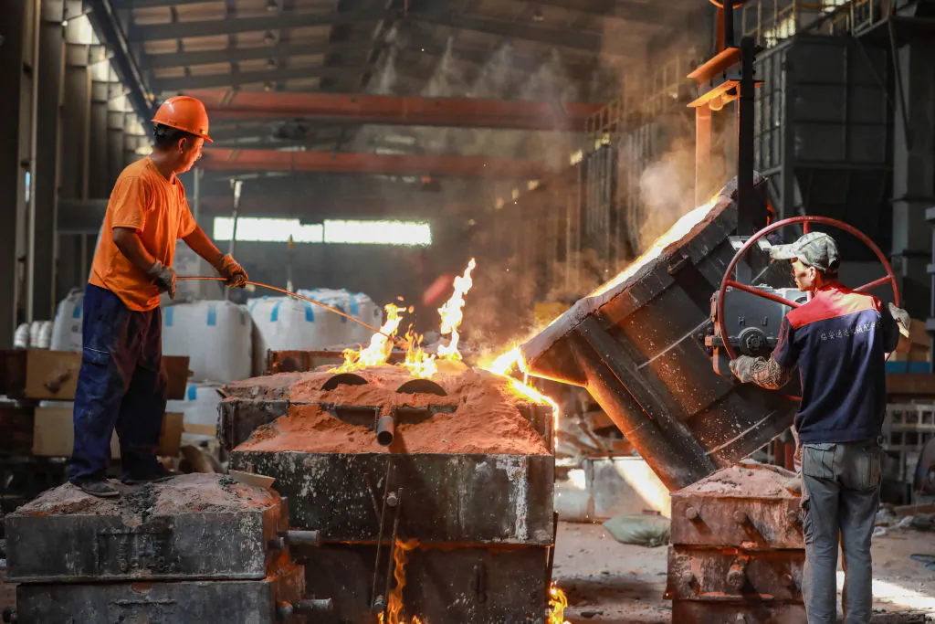Workers conduct casting operations at a factory in Hangzhou, China's eastern Zhejiang Province, on July 15, 2023. (STR/AFP via Getty Images)