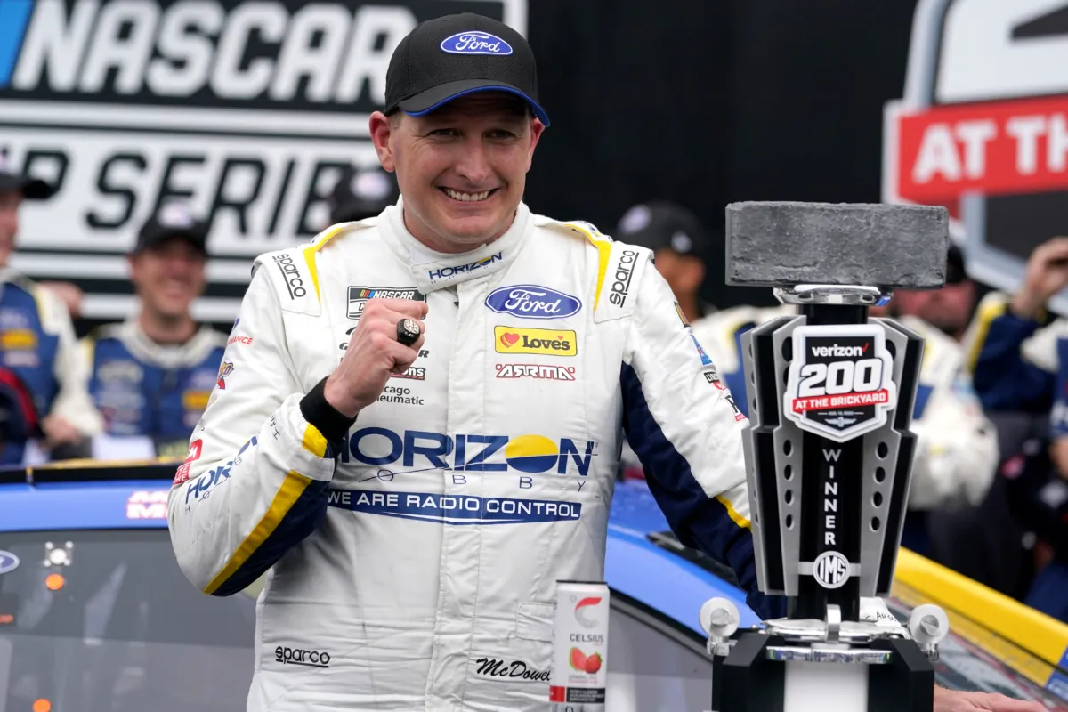 Michael McDowell poses with the trophy after winning the NASCAR Cup Series auto race at Indianapolis Motor Speedway in Indianapolis on Aug. 13, 2023. (Michael Conroy/AP Photo)