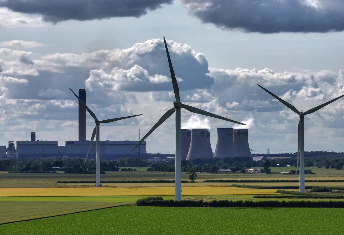 Wind turbines generate electricity as the Drax Power Station in the background also generates electricity in Selby, England, on June 29, 2023. (Christopher Furlong/Getty Images)