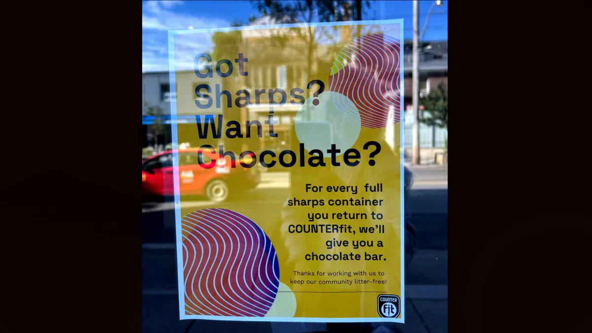 A poster on the door of Toronto's South Riverdale Community Health Centre, which contains a safe injection site, is seen advertising chocolate in exchange for used needles on Aug . 13, 2023. (Courtesy of Ginny Roth)