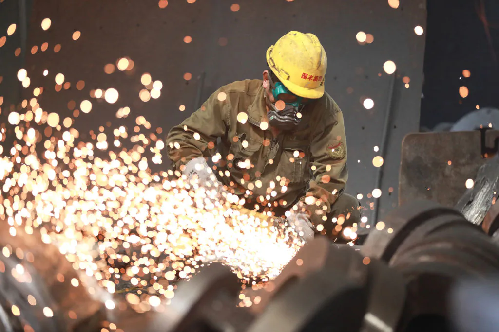 A worker welding metal at a factory in Hangzhou in China's Zhejiang Province on July 15, 2023. (STR/AFP via Getty Images)