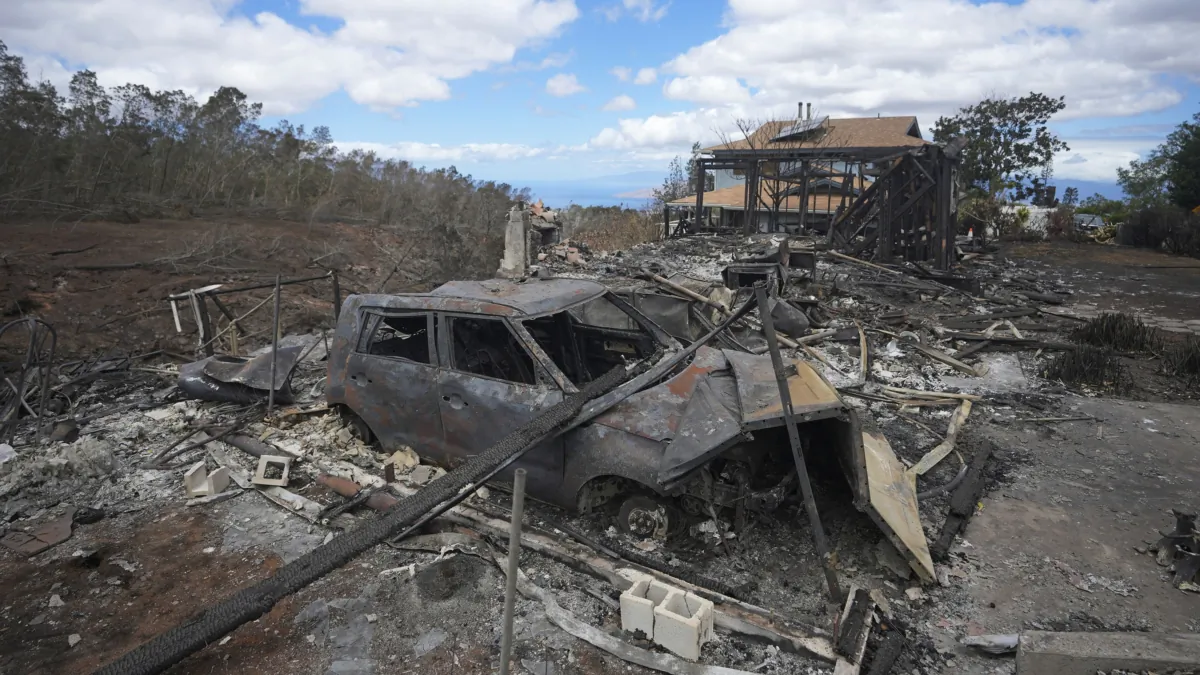The charred remains of a vehicle sit near a home destroyed by wildfire in Kula, Hawaii, on Aug. 14, 2023. (Rick Bowmer/AP Photo)
