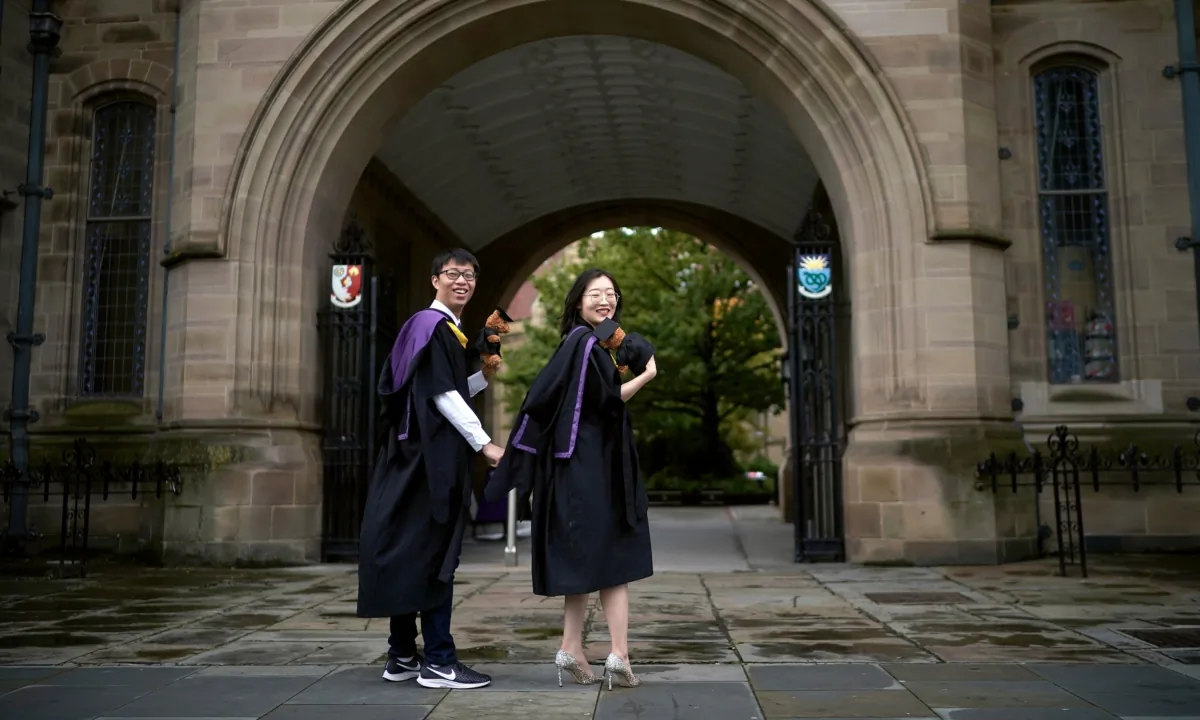Chinese students stage their December graduation photographs early as they prepare to fly home early due to the pandemic in Manchester, England, on Oct. 7, 2020. (Christopher Furlong/Getty Images)