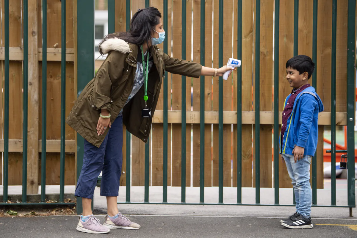 A child has his temperature checked by a teacher before entering Earlham Primary School, in London, on June 10, 2020. (Justin Setterfield/Getty Images)