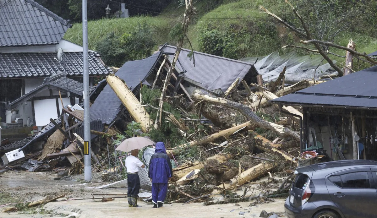 People stand by a mudslide site following a storm in Ayabe, Kyoto prefecture, western Japan, on Aug. 15, 2023. (Kyodo News via AP)