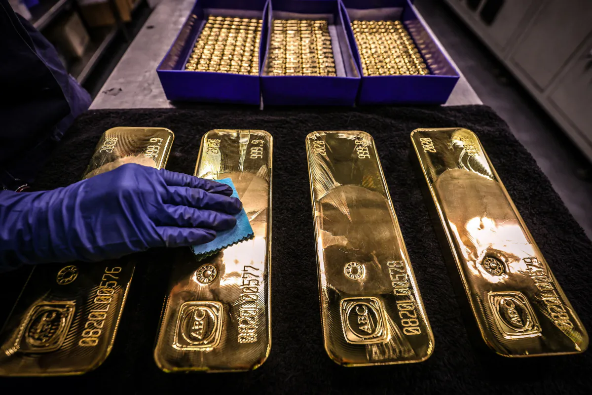 A worker polishes gold bullion bars at the ABC Refinery in Sydney on Aug. 5, 2020. (David Gray /AFP via Getty Images)