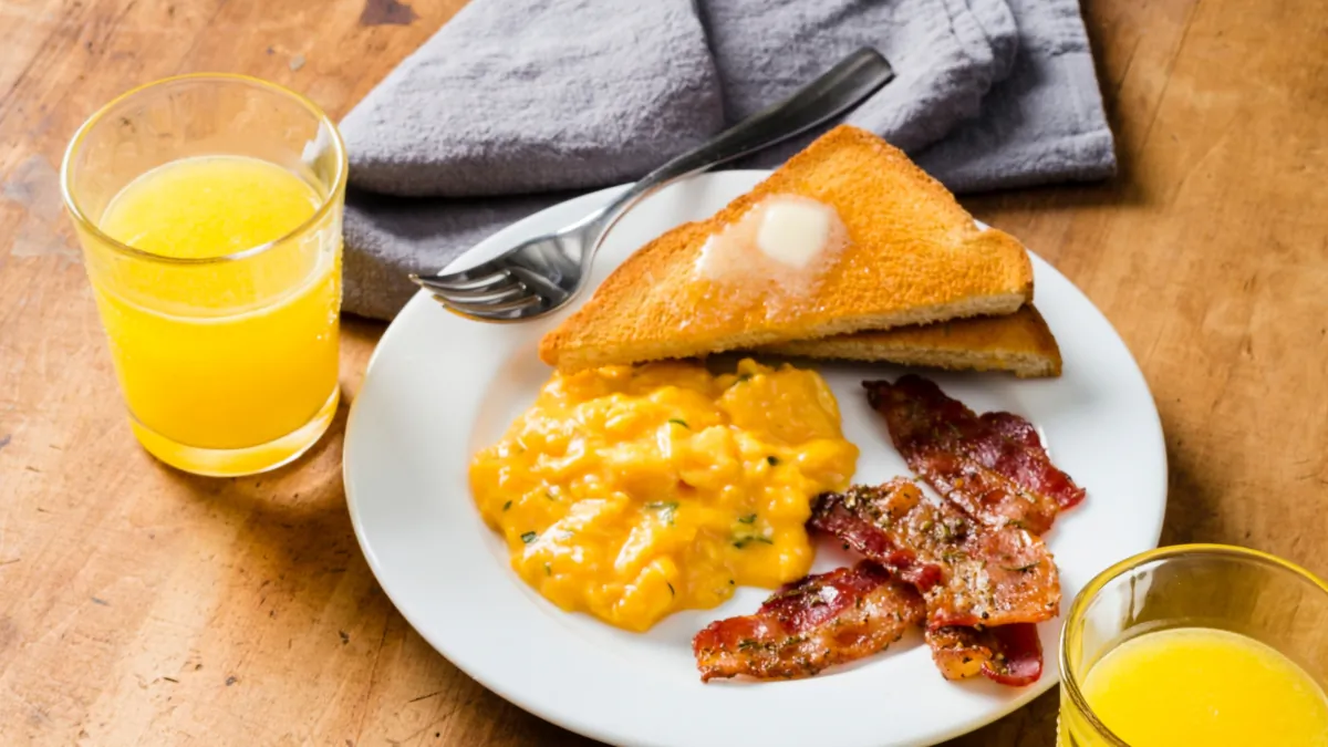 Luscious candied bacon and French-style scrambled eggs make an impressive breakfast. (Daniel J. van Ackere/TNS)