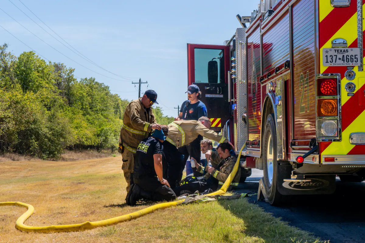 Members of the Hays County Emergency Service Districts and the Kyle and Buda Fire Departments rest together while combatting a wildfire during an excessive heat warning in Hays County, Texas on Aug. 8, 2023. (Brandon Bell/Getty Images)