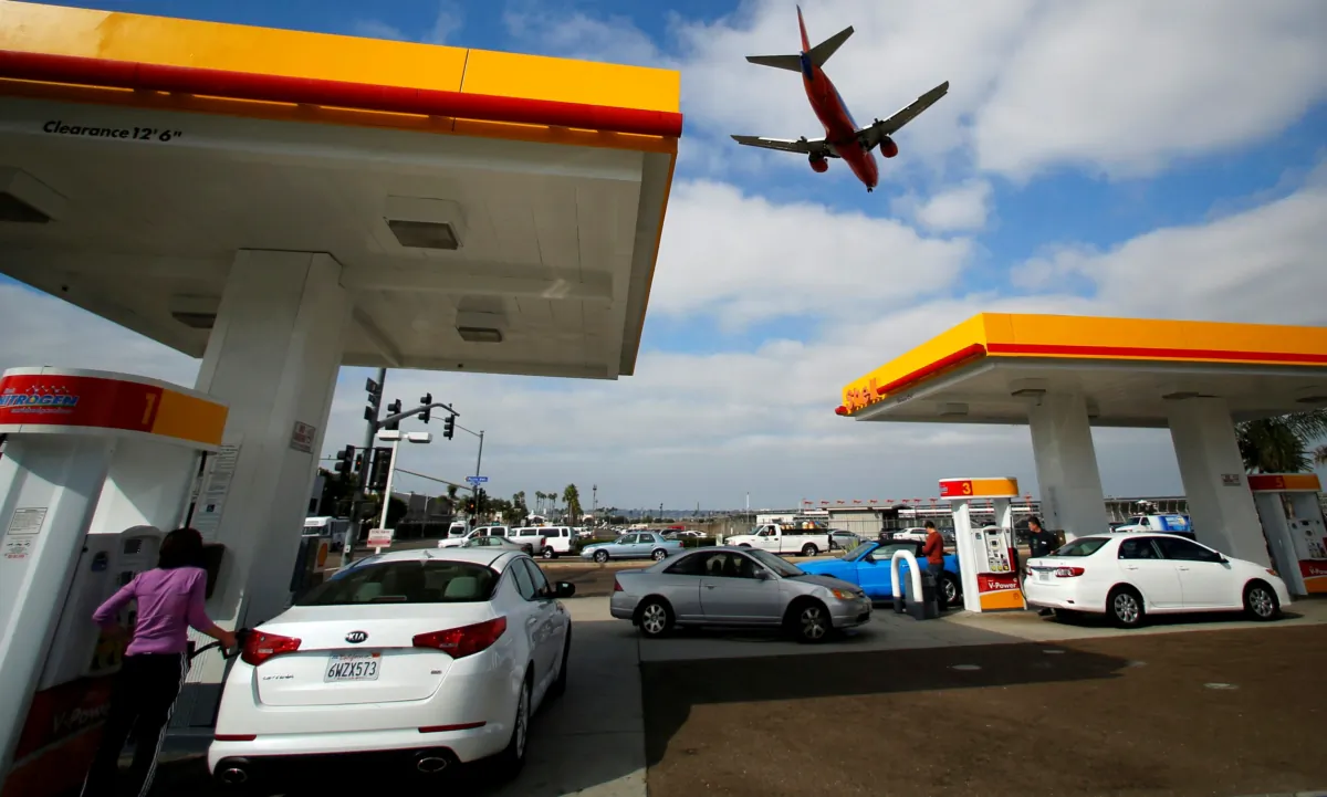 Consumers purchase gasoline at a gas station as a plane approaches to land at the airport in San Diego on Oct. 8, 2012. (Mike Blake/Reuters)