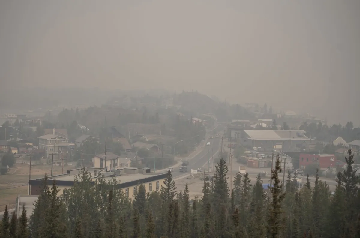 Heavy smoke from nearby wildfires fills the sky in Yellowknife on Aug. 15, 2023. (The Canadian Press/Angela Gzowski)