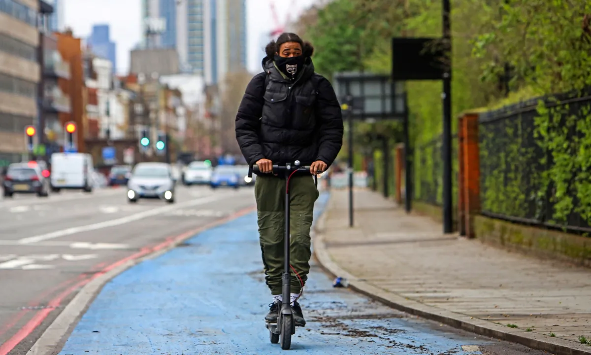 A person rides an electric scooter along the Cycle Superhighway in Oval, south London, on April 1, 2023. (Susannah Ireland/AFP via Getty Images)