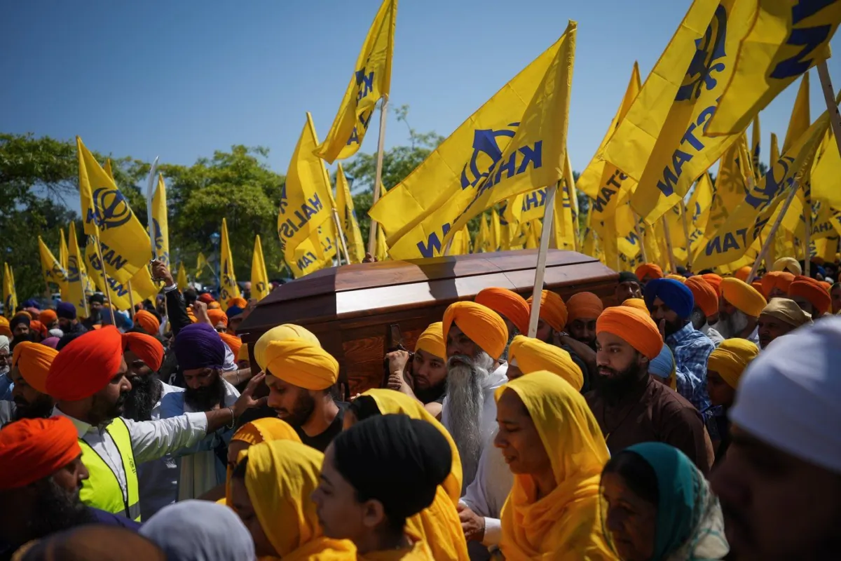 Mourners carry the casket of Sikh community leader and temple president Hardeep Singh Nijjar during Antim Darshan, the first part of a day-long funeral service for him, in Surrey, B.C., on June 25, 2023. (the Canadian Press/Darryl Dyck)