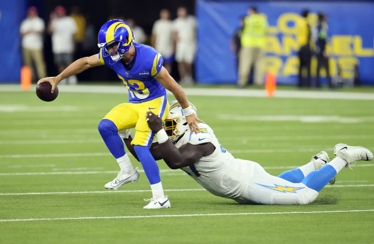 Quarterback Stetson Bennett (13) of the Los Angeles Rams is sacked by defensive tackle CJ Okoye (67) of the Los Angeles Chargers during the second half of a pre-season NFL game at SoFi Stadium in Inglewood, Calif., on August 12, 2023. (Kevork Djansezian/Getty Images)