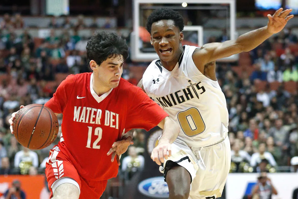 Spencer Freedman (12) of Mater Dei High School drives to the basket while being guarded by Gianni Hunt (0) of Bishop Montgomery High School during the game against Bishop Montgomery High School at the Honda Center in Anaheim, Calif., on March 4, 2017. (Josh Lefkowitz/Getty Images)